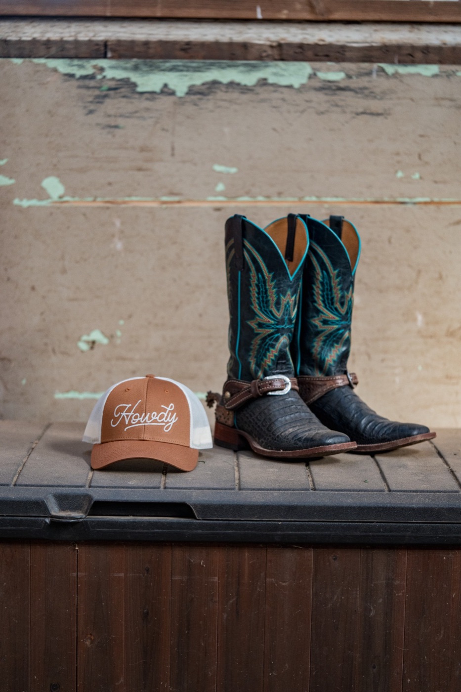 Howdy cap beside embroidered cowboy boots