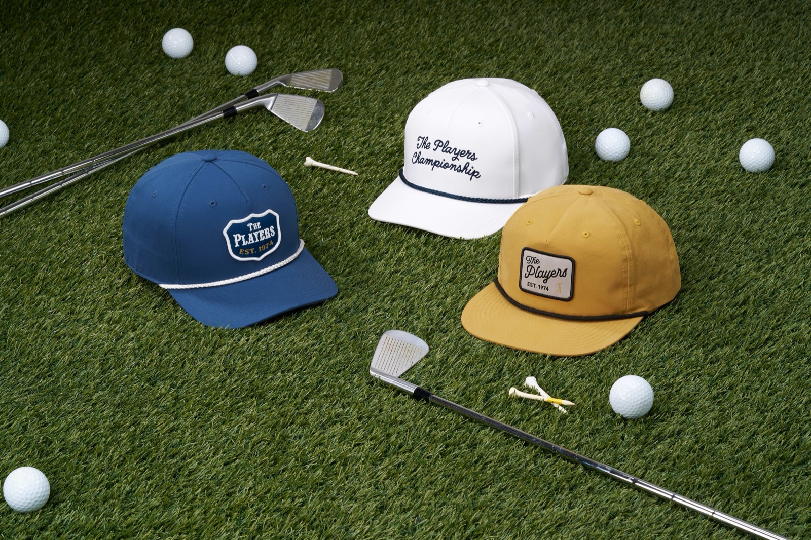 Richardson THE PLAYERS caps laid out on turf with golf clubs and balls
